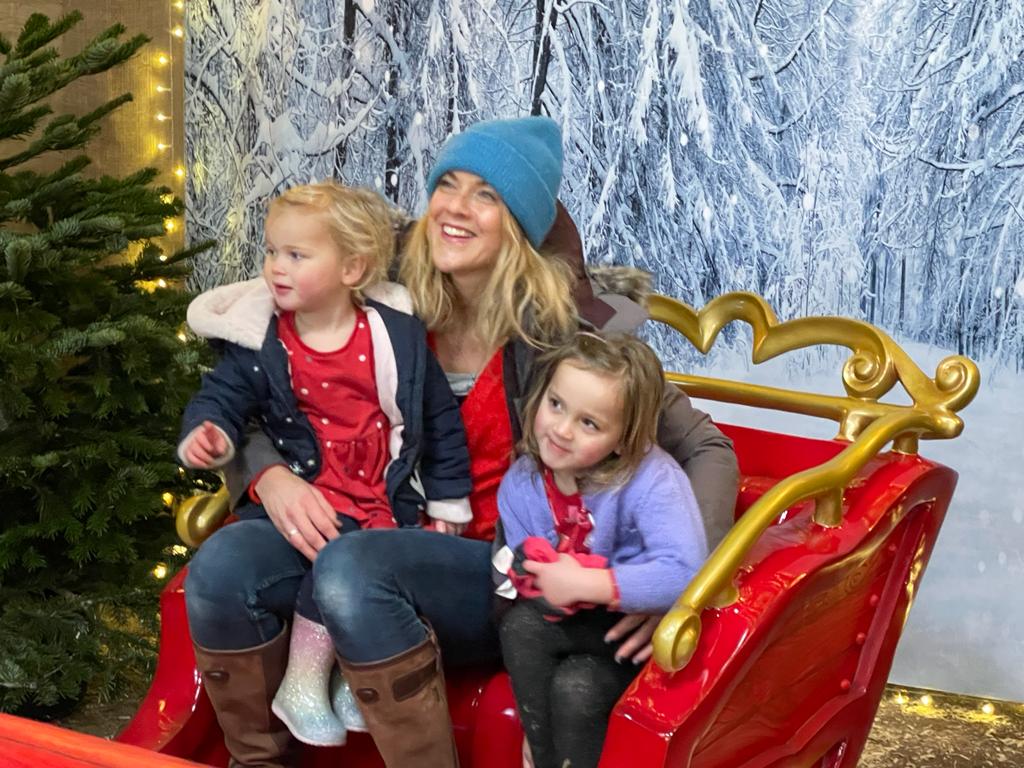 Mother and children in a christmas sleigh at farmer palmers near Poole twilight event
