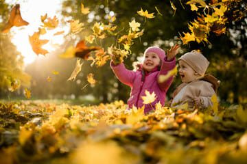 kids playing in the Autumn leaves