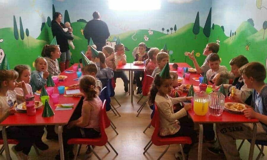 children sitting at tables having birthday party at farmer palmers