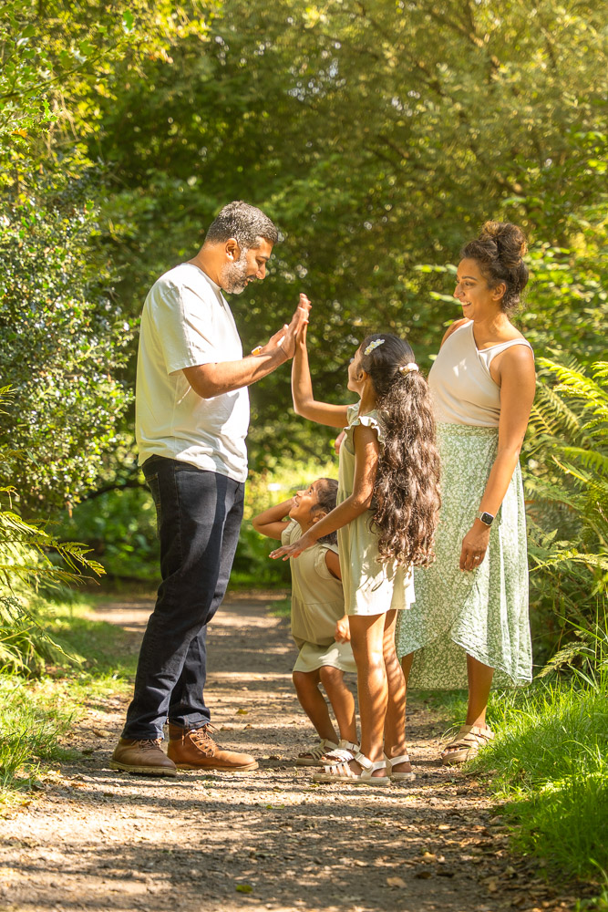 Father and daughters doing a high five with their hands.