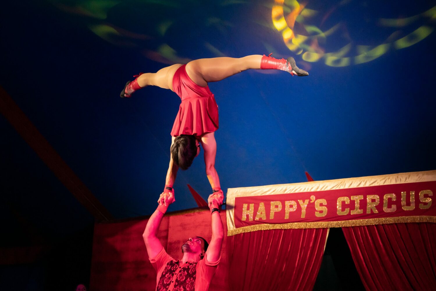 Happys Circus performers. Woman balancing on hands doing splits
