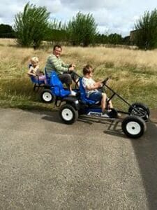 Pedal go-karts with father and children at Farmer Palmers