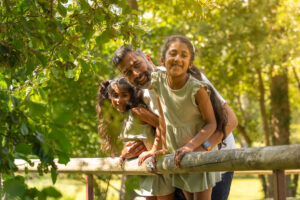 Dad and his children standing on a bridge in farmer palmers shady woodland walk