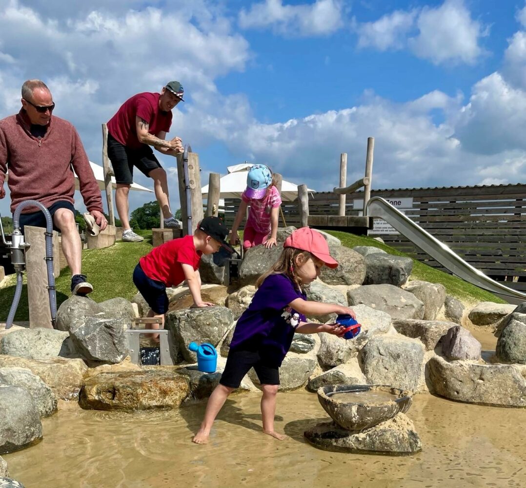 dads playing with children in the water play